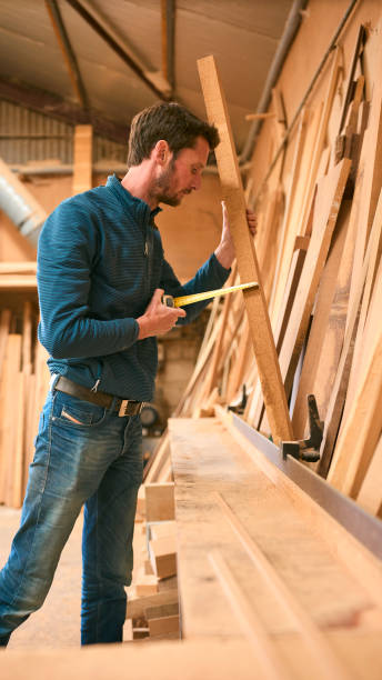 istock Carpenter Working In Woodwork Workshop Measuring Wood For Project 2152883639
