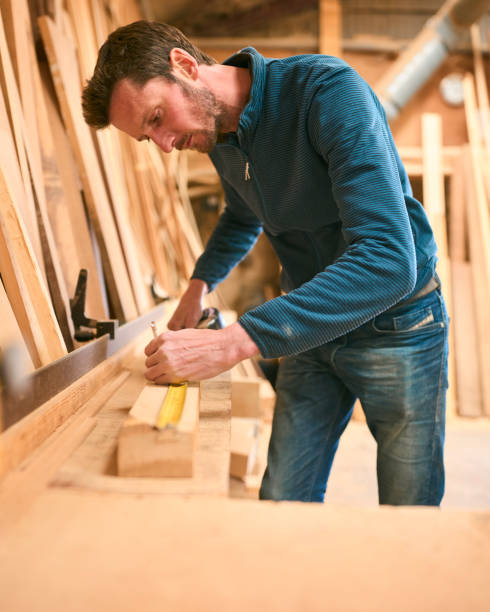 istock Carpenter Working In Woodwork Workshop Measuring Wood For Project 2152883716