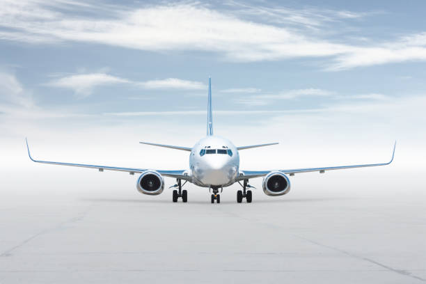istock Front view of the white passenger jetliner isolated on bright background with sky 2152886715
