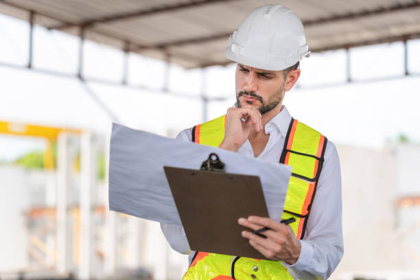 istock Engineer man checking inventory in the precast factory site, Foreman worker with blueprints at construction site 2152889019