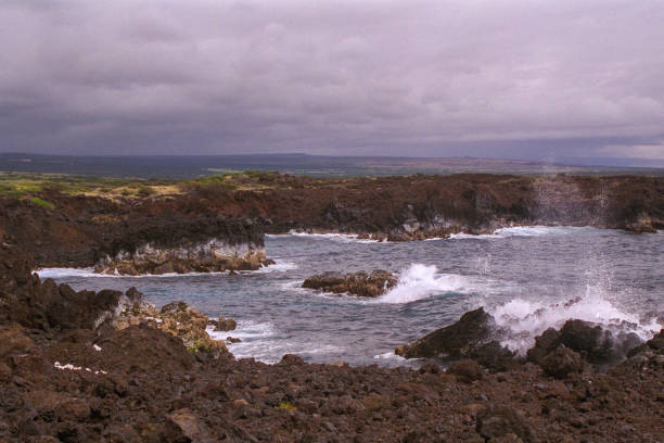 istock Nature's drama unfolds as waves lash against volcanic rocks under a brooding sky. 2152893753