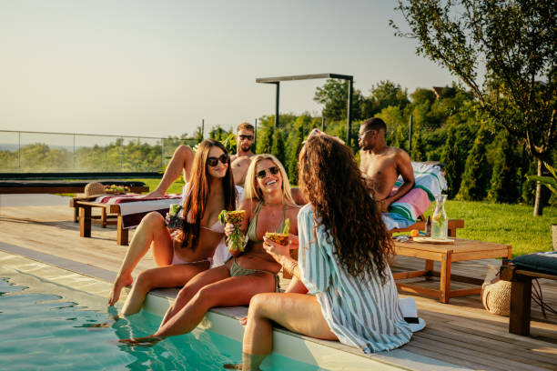 istock Three girls sitting by the pool drinking cocktails 2152894331