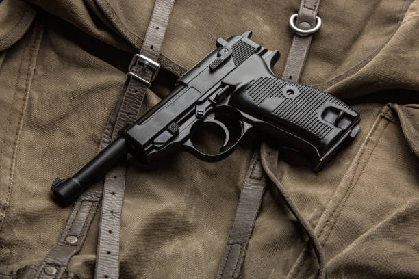 istock German vintage 9mm pistol from the Second World War. Background from an old canvas military backpack. 2152902948
