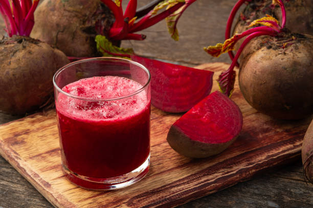 Beetroot juice in a glass and fresh beetroot on wooden plate.Healthy drinks concept