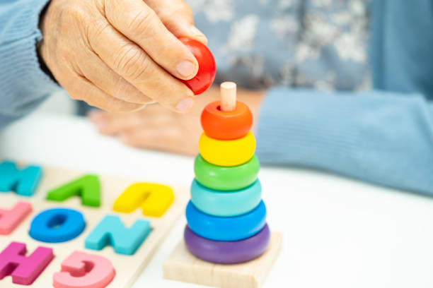 istock Alzheimer disease AD, Asian elderly woman patient suffering from dementia learn practical motor skills rehabilitation. 2152909689