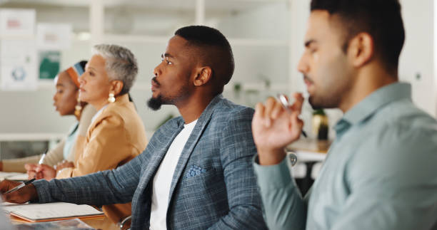 istock Business people, office and writing notes in group, training or watch video for development in career. Men, women and listening to tutorial with notebook, coaching or studying at creative workplace 2152910279