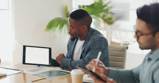 istock Business people, meeting and tablet screen for data analytics, results or progress report on startup revenue. Trader, analyst or man talking to clients with graph, chart or digital stats for trading 2152910289