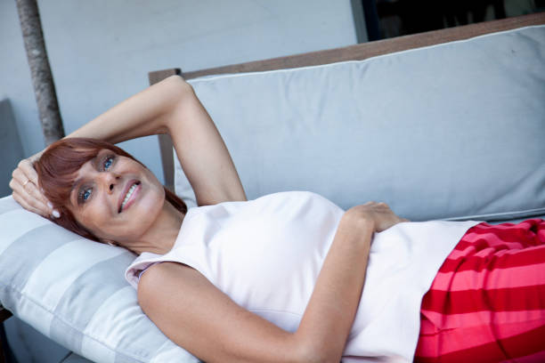 Happy woman smiling lying down in the sofa outdoors