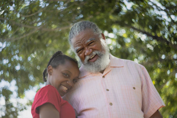 Grandparents with their granddaughter outdoors happy and together.