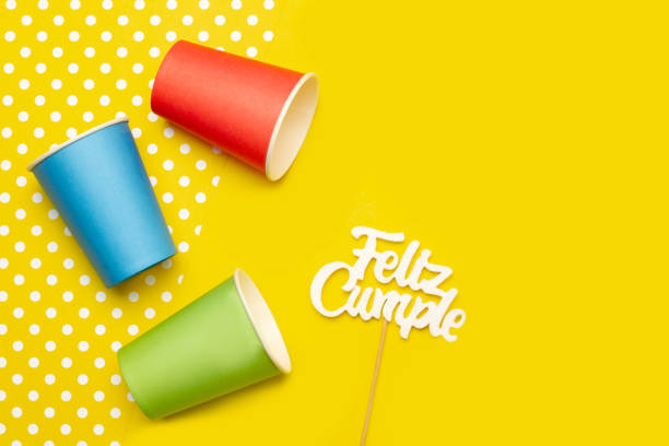 istock Colored paper drinking glass on a yellow background with copy space (trad. happy birthday) 2152918482
