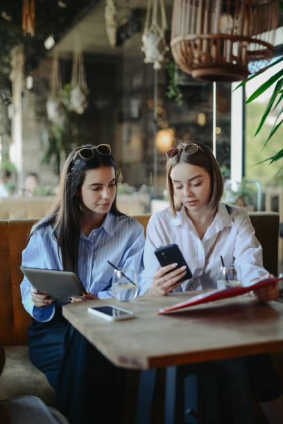 istock Smart Investing By Two Female Coworkers Using Digital Tablet, Smartphone And Graphic Charts 2152920006
