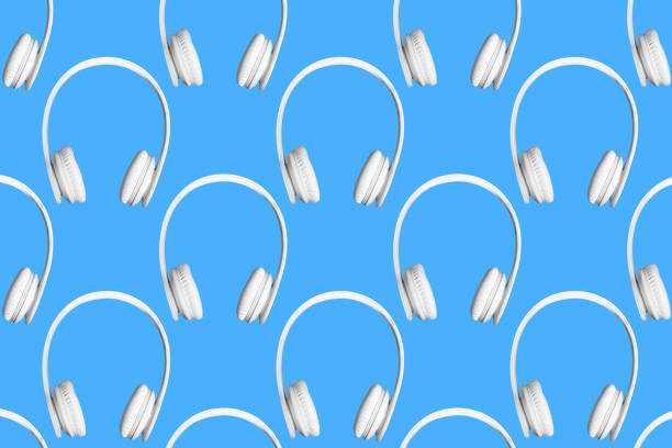 Modern pattern of white wireless headphones on blue background.