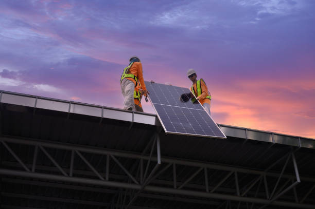 istock Worker installs solar panels. Worker installs solar panels at a solar farm field. 2152922546