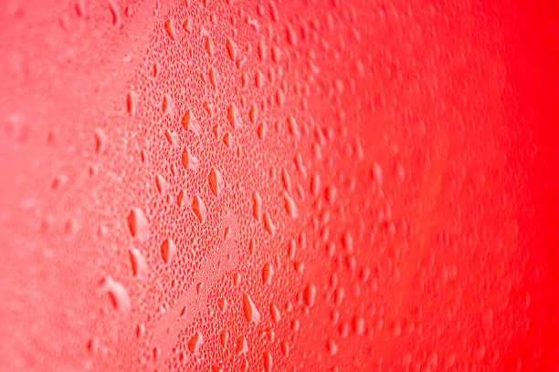 istock Water drops on red background. Water droplets on the glass. 2152922568