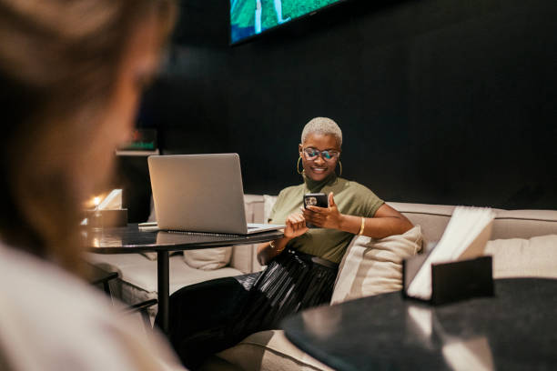 Business woman using smart phone at hotel bar stock photo