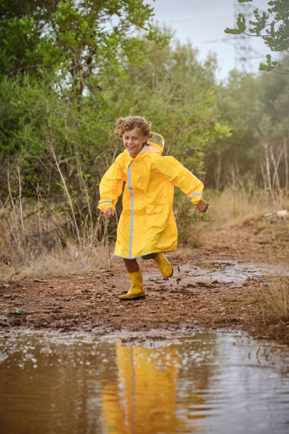 istock Little boy in raincoat running in countryside 2152930107