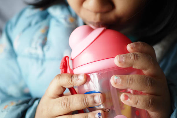 Two year old girl lifestyle portrait holding beaker