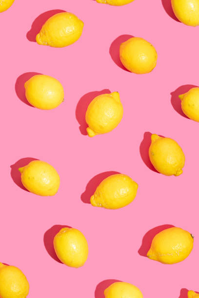 Pattern made of lemons fruit on a pink background. Summer fruit concept.