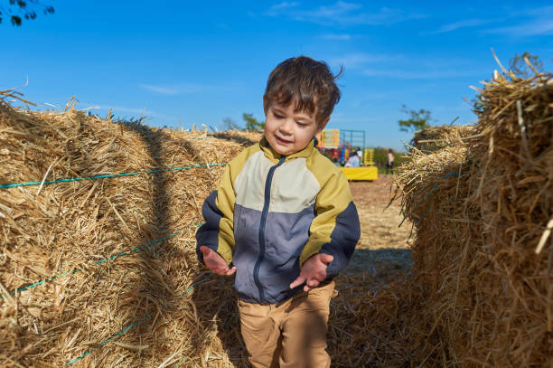 cute boy running around in the hay stacks on Halloween