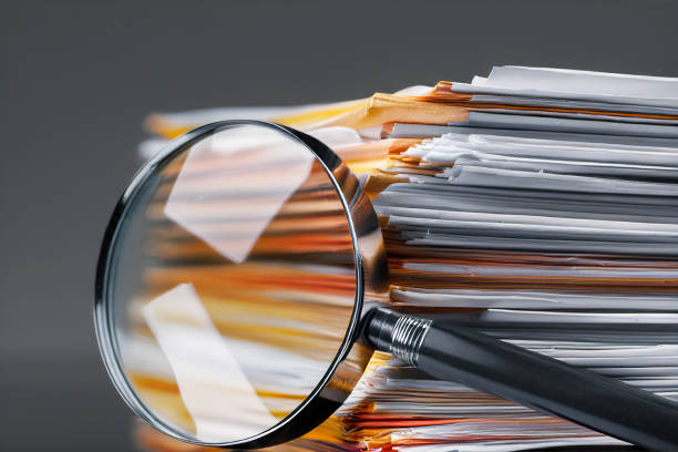 istock Pile of binders partially obscured by a magnifying glass 2152942697