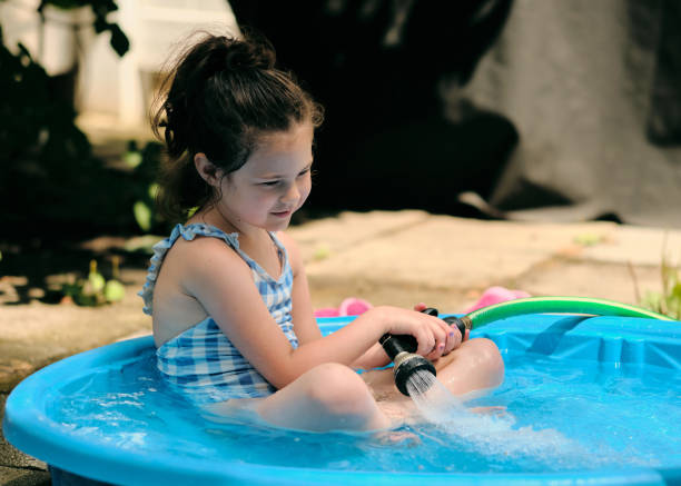 istock Siblings playing near a water basin in the backyard 2152944356