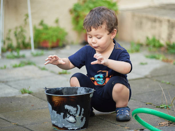 istock cute toddler playing with water in the backyard 2152944379