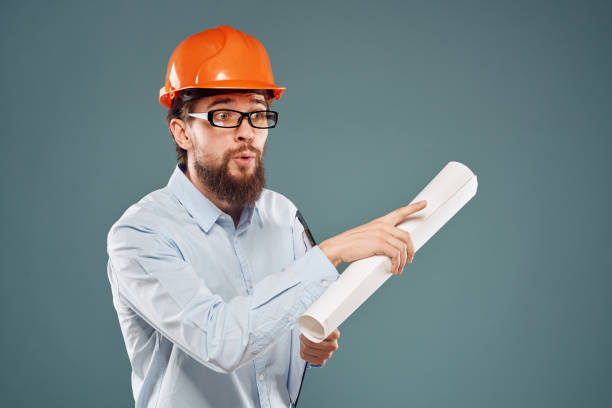 istock Male engineer professional orange hard hat safety construction blueprints in hands 2152947488