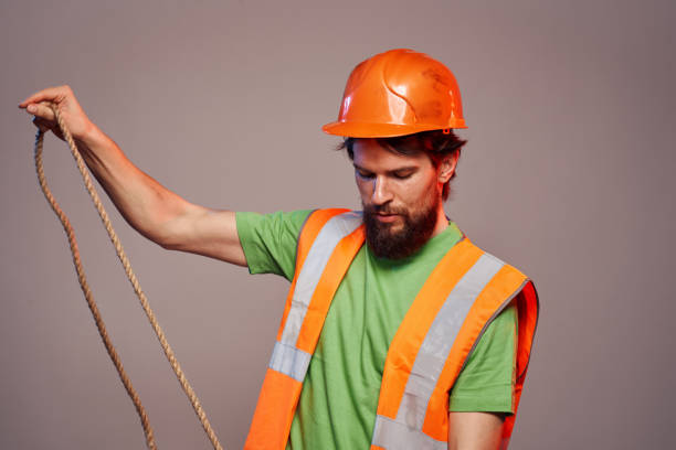 istock Man in construction uniform orange hard hat cropped view over beige background 2152947822