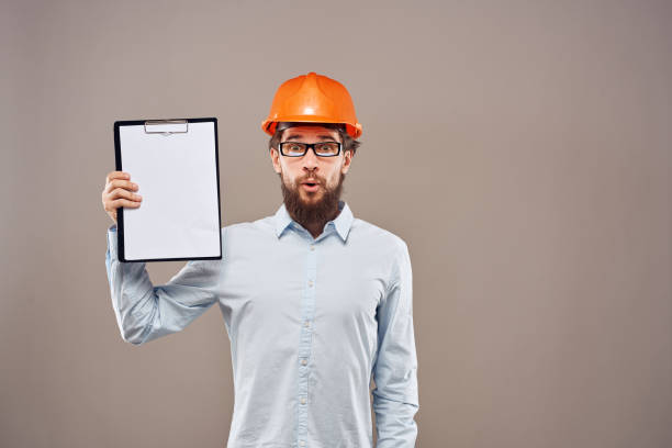 istock Emotional man wearing orange hard hat on industry documents 2152949309