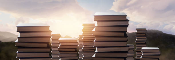 wisdom concept - stack of giant books in beautiful mountain sunset