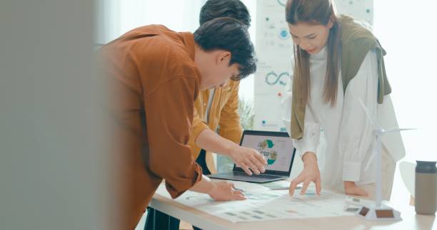istock Team members examine ESG-related documents, pointing and discussing investment strategies for sustainable and renewable energy resources. Eco-Friendly Business Team Discussing ESG Goals. 2152953040