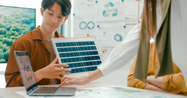 istock Closeup of diverse team collaborates on renewable energy solutions, with a focus on solar panel technology and sustainable business practices. Eco-Friendly Business Team Discussing ESG Goals. 2152953056