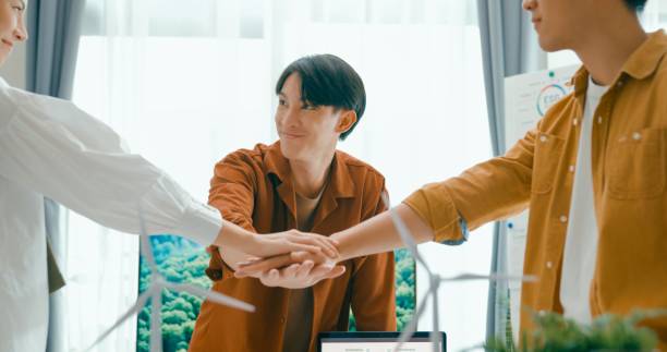 istock Diverse team unites hands over desk with renewable energy models, symbolizing cooperation and agreement on sustainable business practices.Eco-Friendly Business Team Discussing ESG Goals. 2152953067