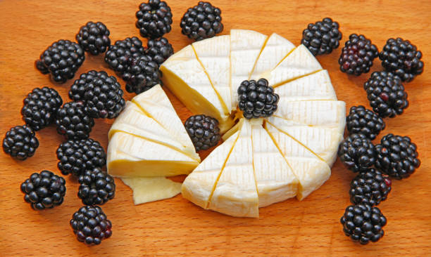 istock Cheese with blueberries on a wooden board. Sliced cheese with berries 2152954320