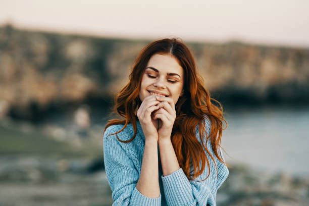 istock pretty red-haired woman outdoors rocky mountains emotions 2152955628
