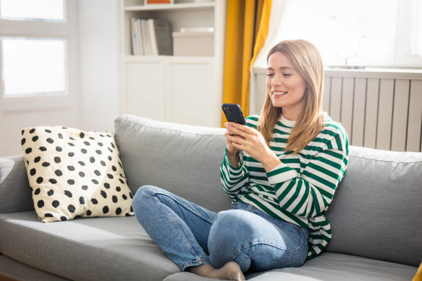 istock Young woman using a smart phone at home 2152960595
