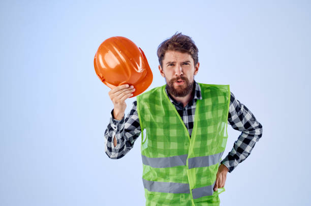 bearded man green vest orange helmet workflow hand gestures Studio. High quality photo