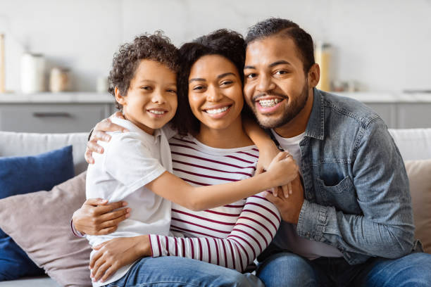 istock Man, Woman, and Child Sitting on a Couch, Hugging 2152962630