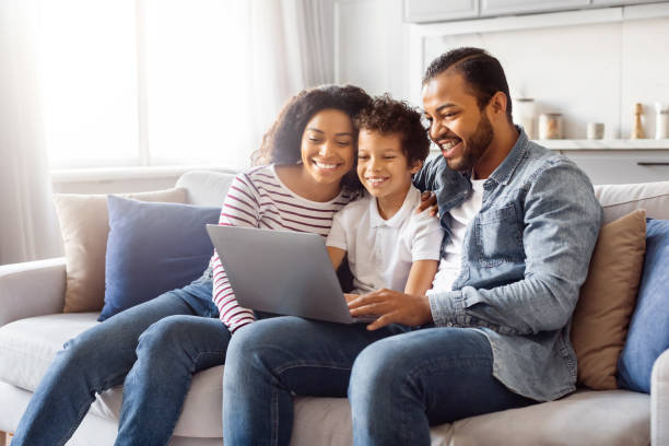 Family Sitting on a Couch Looking at a Laptop