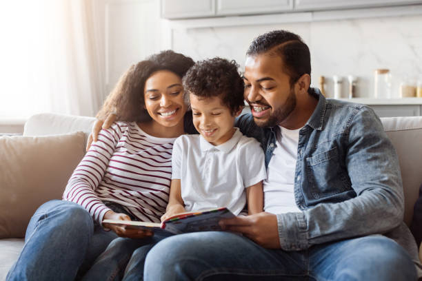 A Family Sitting on a Couch Looking at a Book