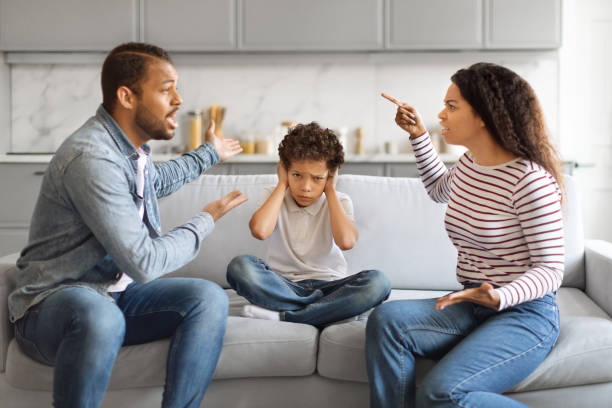 Parental Quarrels. Black Man And Woman Arguing In Front Of Their Son Parental Quarrels. Black Man And Woman Arguing In Front Of Their Son, Upset Little Boy Covering Ears With Hands Not To Listen Conflict, Stressed Male Kid Sitting Between Shouting Parents man closing ears photos stock pictures, royalty-free photos & images