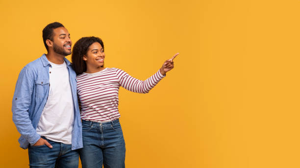 istock Check This. Happy Black Spouses Pointing Aside At Copy Space With Finger 2152963665