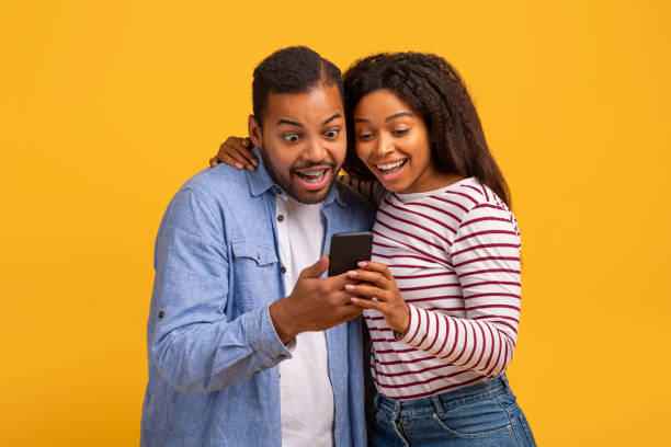 istock Great App. Excited black couple looking at smartphone in their hands 2152963734