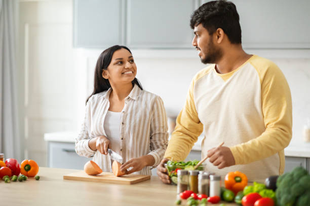 istock Indian Spouses Having Conversation While Preparing Food In Cozy Kitchen 2152965915