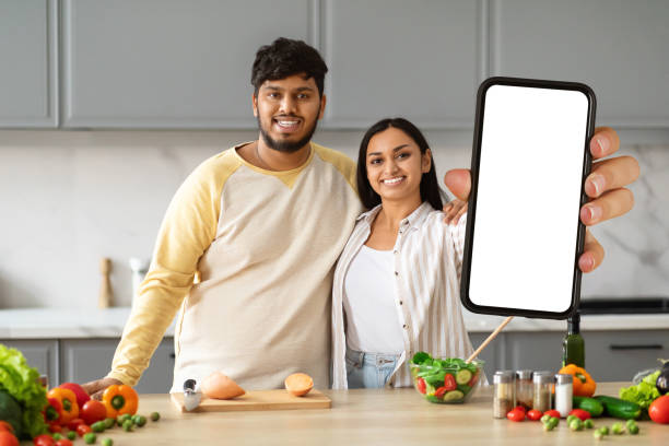 istock Beautiful loving spouses making food, watching video content on phone 2152965921