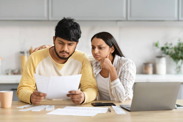 istock Upset indian husband and wife checking bills, kitchen interior 2152965978
