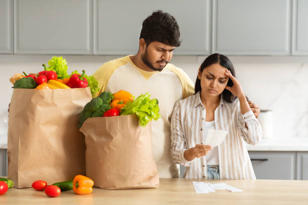 istock Frustrated indian couple checking bills after grocery shopping 2152966012