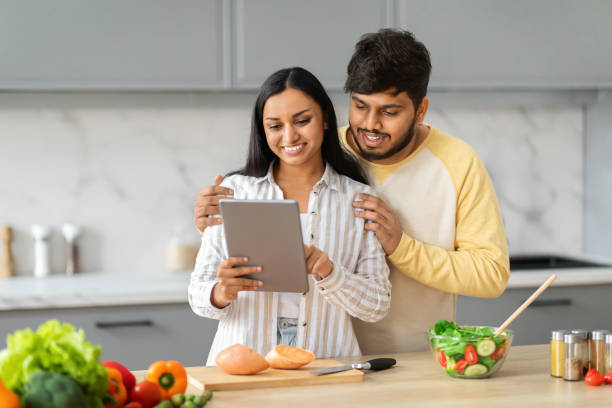istock Happy eastern man and woman using tablet white cooking 2152966079