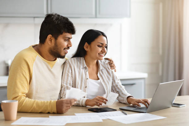 istock Cheerful indian spouses paying bills on Internet from home 2152966094