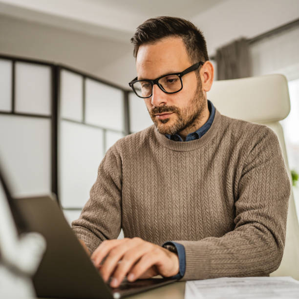 istock One adult man sit at office and look, read document on laptop at office 2152966228